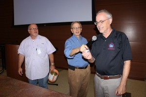 Robin Hudson and Jon Reise looking on as Frank Revitte pulls Dave Thomas', K5CGX, name as winner of the 50-50 raffle